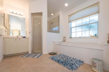 En-suite bathroom with shower cubicle, bathtub and twin vanity units