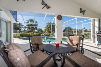 Comfy shaded, padded poolside seating beneath ceiling fan